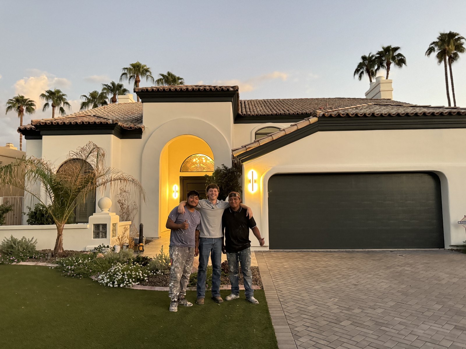 SLW Painting crew in front of a finished Spanish-style home at dusk